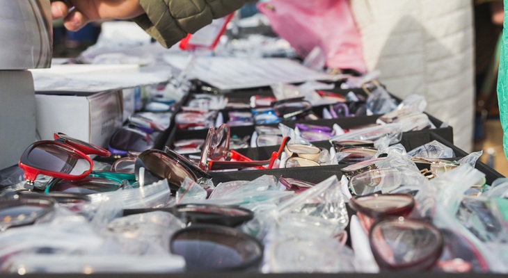 Primo piano di occhiali venduti illegalmente su strada da venditori abusivi. Concetto di contraffazione e commercio illegale.